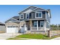 Beautiful two-story home with a stone accent, covered porch, and a well-maintained lawn at 1102 Ridgefield Dr, Berthoud, CO 80513