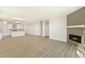 Open-concept space featuring a fireplace, hardwood floors, and a modern kitchen with an island at 1102 Ridgefield Dr, Berthoud, CO 80513