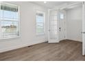 Bright living room with wood floors, white walls, and large windows with white blinds at 1102 Ridgefield Dr, Berthoud, CO 80513
