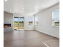 Open living room featuring hardwood floors, a modern fireplace, and sliding glass doors to the outside at 1102 Ridgefield Dr, Berthoud, CO 80513