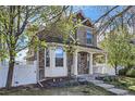 Charming two-story home boasts a welcoming front porch and beautifully maintained landscaping at 736 Trenton St, Denver, CO 80230
