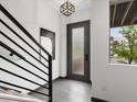 Modern entryway with sleek staircase, frosted glass door and contemporary artwork at 8336 E 35Th Ave, Denver, CO 80238
