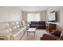 Cozy living room featuring plush seating, carpet flooring and natural light from the large windows at 8205 Dudley Way, Arvada, CO 80005