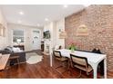 The home features a cozy living room with a decorative fireplace and exposed brick near the dining area at 3220 W 24Th Ave, Denver, CO 80211
