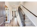 Inviting foyer with hardwood floors, staircase with iron railing, and views into other rooms at 42754 Calusa Pines Rd, Elizabeth, CO 80107