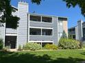 Exterior view of a gray two-story condominium building with patios, green grass and lush landscaping at 4676 White Rock Cir # 12, Boulder, CO 80301