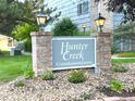 Well-maintained sign for Hunter Creek Condominiums with brick accents and manicured landscaping at 4676 White Rock Cir # 12, Boulder, CO 80301