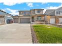 Charming home featuring a front porch, stone accents, well-maintained lawn, and a two-car garage at 13489 Valentia Pl, Thornton, CO 80602