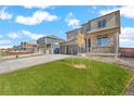 Charming home featuring a front porch, stone accents, well-maintained lawn, and a two-car garage at 13489 Valentia Pl, Thornton, CO 80602