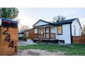 Charming home featuring fresh white siding, black trim, front porch, and easy-to-read address numbers on the mailbox at 2441 W 55Th Ave, Denver, CO 80221