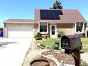 Inviting home exterior with solar panels, well-maintained lawn, and a convenient attached garage at 4383 S Eagle Cir, Aurora, CO 80015