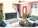 Comfortable living room featuring a fireplace, staircase, ceiling fan, and a front door at 4383 S Eagle Cir, Aurora, CO 80015