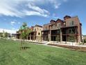 View of the lovely townhomes in a green, landscaped neighborhood on a sunny day at 9662 Browns Peak Cir, Littleton, CO 80125