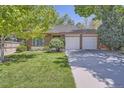 Charming single-story home with a well-manicured lawn and a two-car garage at 8144 W 81St Dr, Arvada, CO 80005
