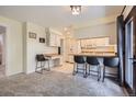 Eat-in kitchen featuring white cabinets, modern appliances, and a breakfast bar with seating at 8144 W 81St Dr, Arvada, CO 80005