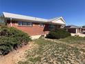Charming brick home featuring a well-maintained front yard with lush green shrubbery at 10885 Mildred Dr, Northglenn, CO 80233