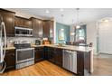 Well-equipped kitchen with stainless steel appliances, dark cabinetry, and hardwood floors at 12704 Leyden St # D, Thornton, CO 80602