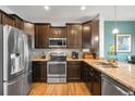 Modern kitchen features stainless steel appliances, dark wood cabinets, and granite countertops at 12704 Leyden St # D, Thornton, CO 80602