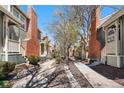 Townhome exteriors with brick chimneys and tree-lined sidewalk with mulch accents at 1981 S Hannibal Ct # B, Aurora, CO 80013