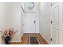 Bright entryway with hardwood floors, closet and eye-catching floral arrangement at 1469 S Ulster St, Denver, CO 80231