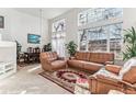 Bright living room featuring large windows, vaulted ceiling, and a comfortable seating arrangement at 1469 S Ulster St, Denver, CO 80231