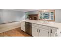 This kitchen features a center island with dishwasher and double basin sink, looking into the Gathering room at 523 E Long Ct, Littleton, CO 80122