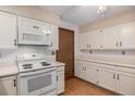 Efficient kitchen layout featuring bright white cabinets, laminated floors, and white appliances at 523 E Long Ct, Littleton, CO 80122