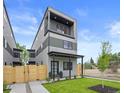 Modern home with two stories, a balcony, well-maintained lawn and decorative fence at 1747 Lowell Blvd, Denver, CO 80204
