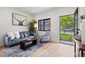 Bright living room featuring hardwood floors, a plush grey sofa and modern decor at 1747 Lowell Blvd, Denver, CO 80204