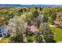An aerial view of the property shows mature trees, blue skies, and surrounding area at 1051 Independence St, Lakewood, CO 80215