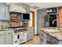 Modern kitchen featuring updated cabinets, granite countertops, stainless steel appliances, and a tiled floor at 1051 Independence St, Lakewood, CO 80215