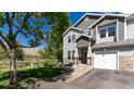 Inviting townhome featuring a neatly landscaped lawn and covered entry at 4797 Flower St, Wheat Ridge, CO 80033