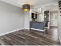 Open kitchen and dining area with modern light fixture and stylish gray accents at 1811 S Quebec Way # 60, Denver, CO 80231