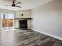 Bright living room with gray-toned flooring, white brick fireplace, and sliding glass doors at 1811 S Quebec Way # 60, Denver, CO 80231