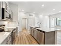 Modern kitchen featuring stainless steel appliances, a kitchen island, and wood flooring at 485 Interlocken Blvd # 106, Broomfield, CO 80021