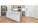 Modern kitchen with an island, stainless steel appliances, wood flooring and gray cabinets at 485 Interlocken Blvd # 106, Broomfield, CO 80021