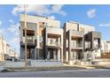 Modern townhouses featuring cantilevered balconies, sleek metal accents, and grey brick, enhanced by natural daylight at 2326 Eliot St # 7, Denver, CO 80211