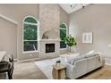 Cozy living room with fireplace, large arched windows offering natural light, and modern decor at 9371 Princeton Ln, Highlands Ranch, CO 80130