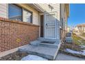 Close-up of a home entrance with red brick and a white security door at 3354 S Flower St # 14, Lakewood, CO 80227