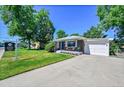 Attractive single-story brick home with a manicured lawn, a driveway, and an attached garage at 7011 Poplar St, Commerce City, CO 80022