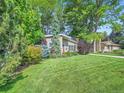 Attractive home with a green lawn and mature trees surrounding the house, creating a serene outdoor space at 2609 S Dahlia St, Denver, CO 80222