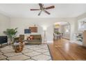 Bright living room showcasing hardwood floors, ceiling fan, and seamless transition to dining area at 2318 S Lincoln St, Denver, CO 80210