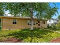 Inviting single-story home featuring lush front lawn and large shade tree enhancing curb appeal at 5573 S Datura St, Littleton, CO 80120