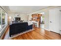 Bright living room featuring hardwood floors, an open layout, and access to the kitchen at 5573 S Datura St, Littleton, CO 80120