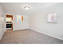 Bright living room featuring neutral carpet, fresh paint, and a kitchen pass-through window at 5549 S Greenwood St, Littleton, CO 80120