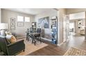 Home office featuring hardwood floors, built-in shelving, and a large art piece at 9902 Cathay St, Commerce City, CO 80022