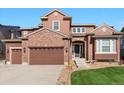 This is an inviting two-story home featuring a brick facade and a three-car garage at 3745 Spanish Oaks Trl, Castle Rock, CO 80108