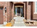 Inviting front entrance with brick archway and manicured landscaping at 3745 Spanish Oaks Trl, Castle Rock, CO 80108