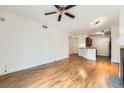 Bright living room features hardwood floors, open layout to kitchen, and ceiling fan at 9079 E Panorama Cir # 309, Englewood, CO 80112