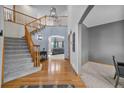 Grand foyer with hardwood floors, staircase, and view into living room at 6445 S Telluride St, Aurora, CO 80016